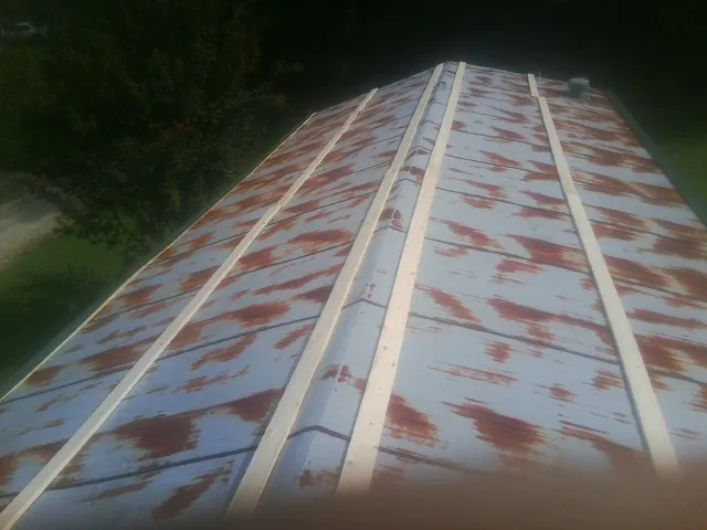 Rusted metal roof panels with new wood purlins before replacement — Storm Damage Roof Repair in Parachute by Roofing Brothers