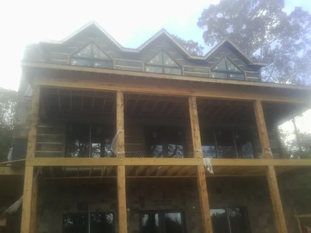 Dormers and porch framing on a large log home under construction — Roof Coating work by our crew in Parachute